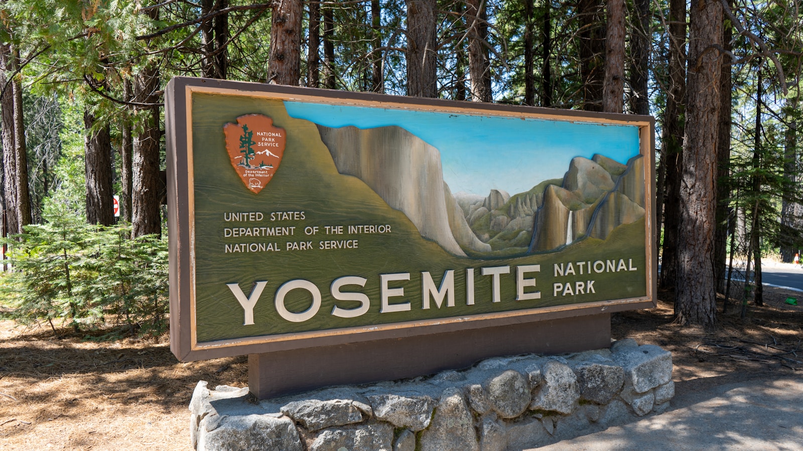 A sign for yosemite national park in the woods