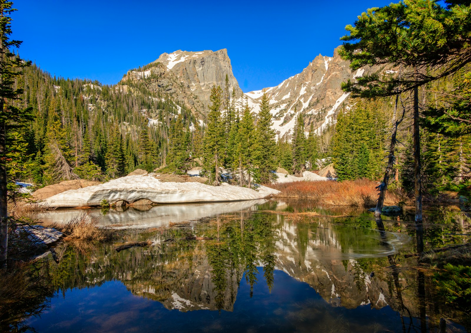 Mountain peaks reflected in a calm alpine lake.